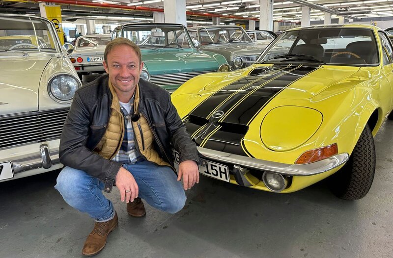 Tobias Kämmerer neben einem echten Klassiker aus Rüsselsheim, einem Opel GT. – Bild: HR/​Lukas Lowack
