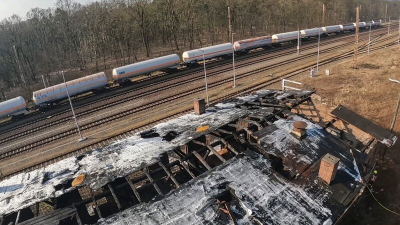 Verbranntes Gebäude neben der Bahnlinie – Bild: Warner Bros. Discovery