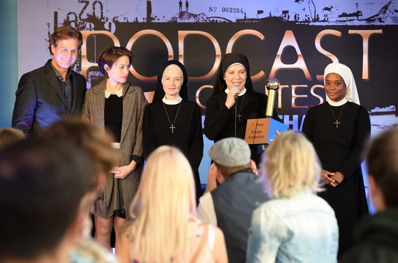 Schwester Agnes (Emanuela von Frankenberg, 3.v.l.), Schwester Hanna (Janina Hartwig, 2.v.r.) und Schwester Lela (Denise M’Baye, r.) bekommen für ihren Klosterpodcast den ersten Preis verliehen. Salm (Thomas Heinze, l.) und Emma Graf (Thekla Hartmann, 2.v.l.) freuen sich mit den Nonnen. – Bild: ARD/​Barbara Bauriedl