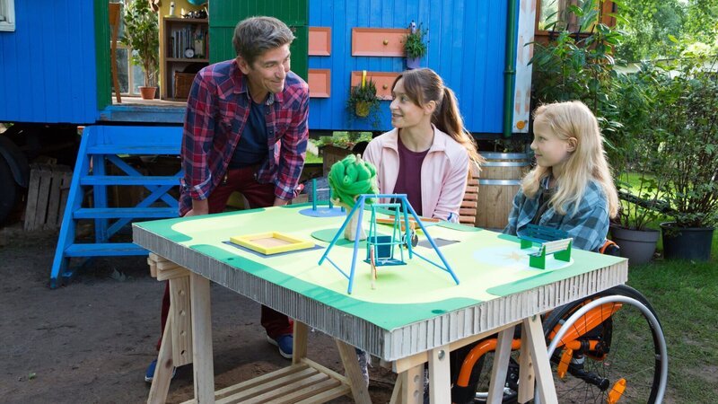 Ronja (Helen Luise Höhle, r.) träumt von einem Weltraum-Spielplatz. Gemeinsam mit Fritz Fuchs (Guido Hammesfahr, M.) und ihrer Schwester Elena (Mascha Schrader, l.) überlegt sie, welche Spielgeräte die Schwerkraft überwinden und die Flieh- und Anziehungskraft nutzen. – Bild: ZDF und Zia Ziarno