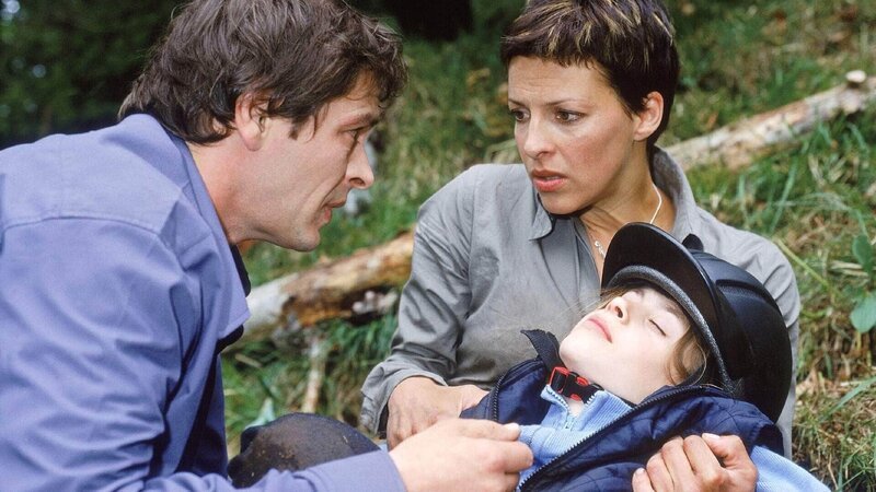 Biggi (Sabine Petzl) und Enrico (Tom Mikulla) haben die Hilferufe eines Kindes gehört und finden die kleine Ulrike (Laura Sonntag), die nach einem Sturz vom Pferd schwer verletzt ist. – Bild: RTL /​ Miguel Dieterich