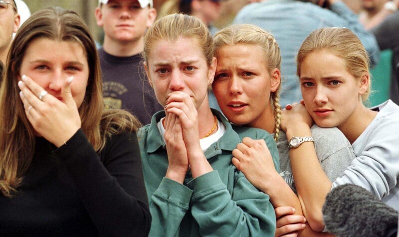 Masakra w szkole w Columbine /​ Students from Columbine High School in Littleton, CO watch as the last of their fellow students are evacuated from the school building 20 April 1999 following a shooting spree at the school, which police feared killed as many as 25 people. Two masked teens stormed their school and blasted fellow students with guns and explosives before turning their weapons on themselves in the rampage.   (Photo credit should read MARK LEFFINGWELL/​AFP/​Getty Images) – Bild: FOX