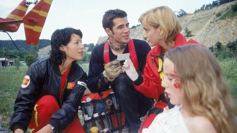 Eine Rockkonzertbühne ist zusammengebrochen und Tina (Sarah Berg, re.) wurde verletzt. Ein weiteres Mal bietet Roadie Florian (Jo Weil) der Medicopter-Crew mit Gina (Julia Cencig, li.) und Karin (Roswitha Meyer) seine Unterstützung an und outet sich als gelernter Sanitäter. – Bild: RTL /​ Miguel Diederich