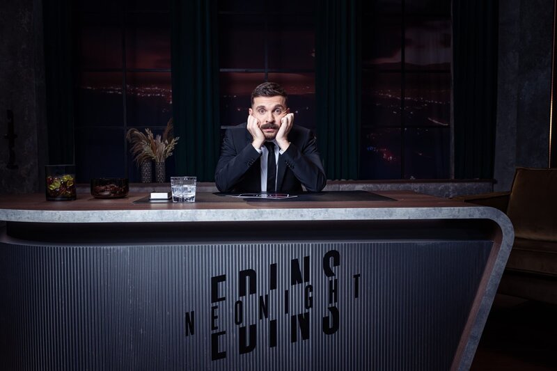 Edin Hasanovic am Schreibtisch seines Late-Night-Studios für „Edins Neo Night“ – Bild: ZDF und Ben Knabe