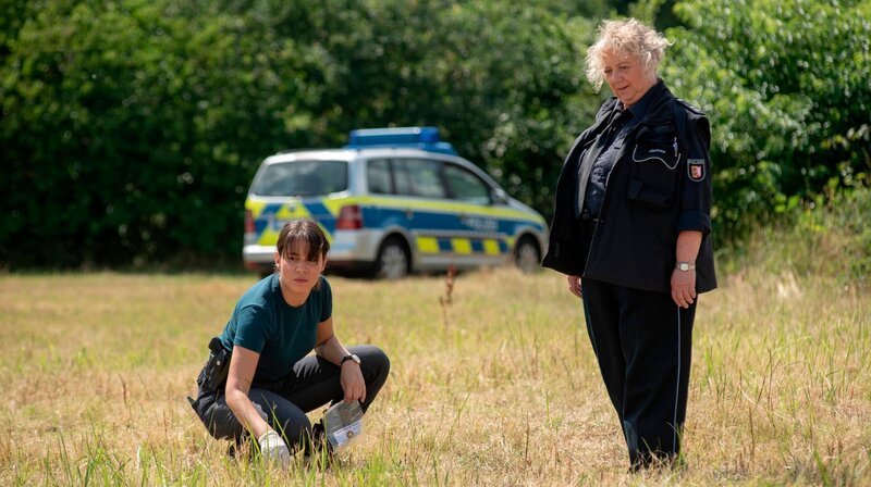 Ein Beweisstück im Gras? Kommissarin Mila Sahin (Almila Bagriacik) und Dorfpolizistin Waltraut Jensen (Regine Hentschel) finden Interessantes. – Bild: NDR/​Thorsten Jander