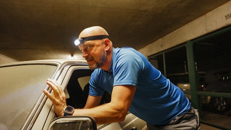 Ralf Gerstenlauer pushes an old Mercedes in an underground car park – Bild: Warner Bros. Discovery, Inc. or its subsidiaries and affiliates
