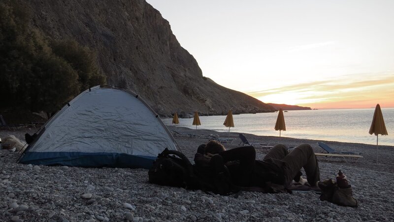 Eine Person ruht sich am Strand neben einem Zelt aus – Bild: xplore