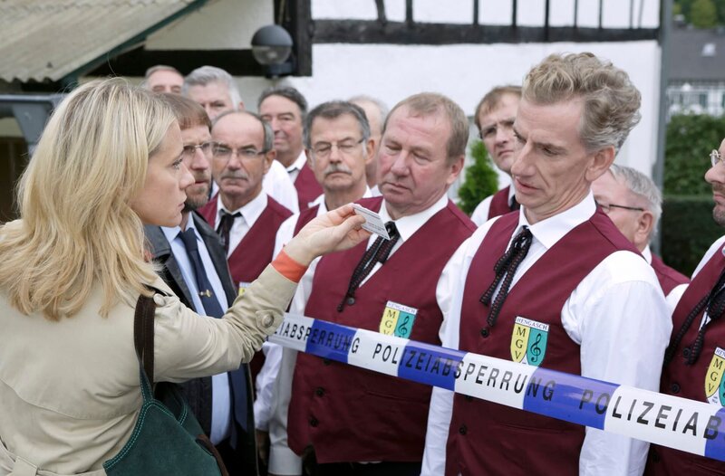 Sophie Haas (Caroline Peters, l.), in Begleitung von Dietmar Schäffer (Bjarne Mädel, 2.v.l.) startet ihre Nachforschungen im Umfeld des Männergesangvereins unter der Leitung von Volker Mauk (Bernd Moss, r.). – Bild: HR/​ARD/​Michael Böhme