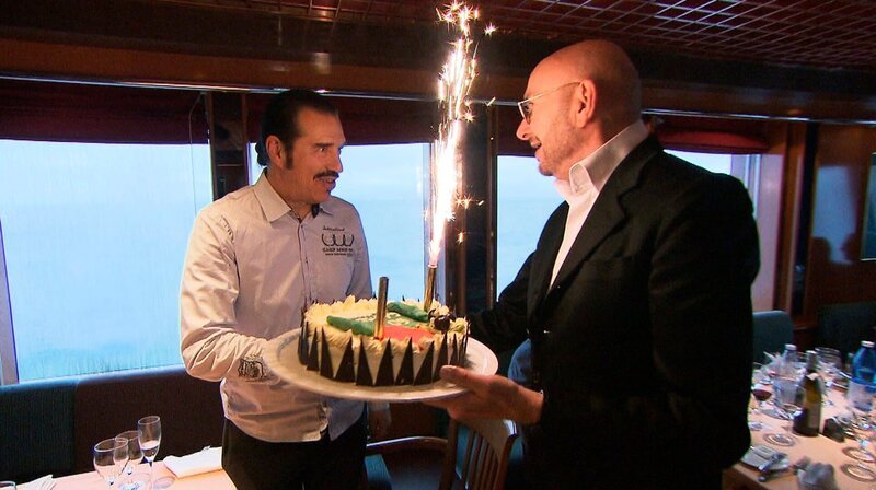 Ralph Morgenstern (re.) überreicht Geburtstagskind Dirk Förster (li.) eine Torte. – Bild: SWR/​Fandango