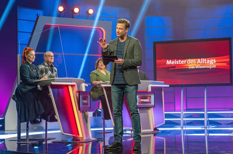 Bereit zum Mitraten? Beim SWR Wissensquiz „Meister des Alltags“ begrüßt Gastgeber Florian (Mitte) seine prominent besetzten Rateteams. Zu sehen sind (v. li.) Moderatorin Enie van de Meiklokjes und Telefonschreck Bodo Bach sowie Comedienne Meltem Kaptan. Den Gewinn spendet „Meister des Alltags“ einem guten Zweck. – Bild: SWR/​Christian Koch