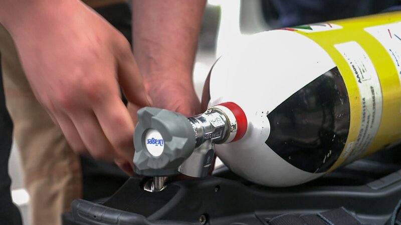 Ein Feuerwehrmann bereitet eine Sauerstoffflasche vor – Bild: DMAX