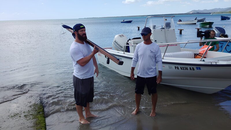 Eric proudly holds his spear gun. Roberto is by his side. – Bild: Discovery Communications /​ Chris Marchand