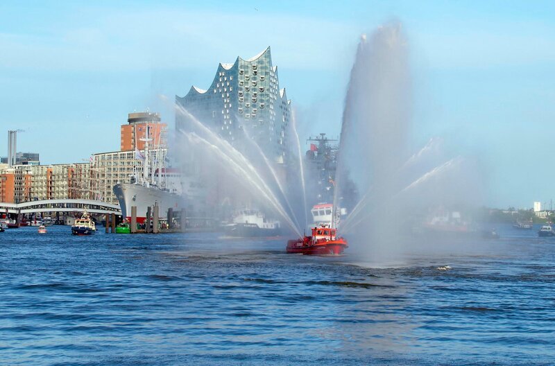 Ein Schlepper beim jährlichen Schlepperballett im Rahmen des Hafengeburtstags. Im Hintergrund die Elbphilharmonie und die Hafencity. – Bild: NDR/​Hagen Thom/​Wetterbild
