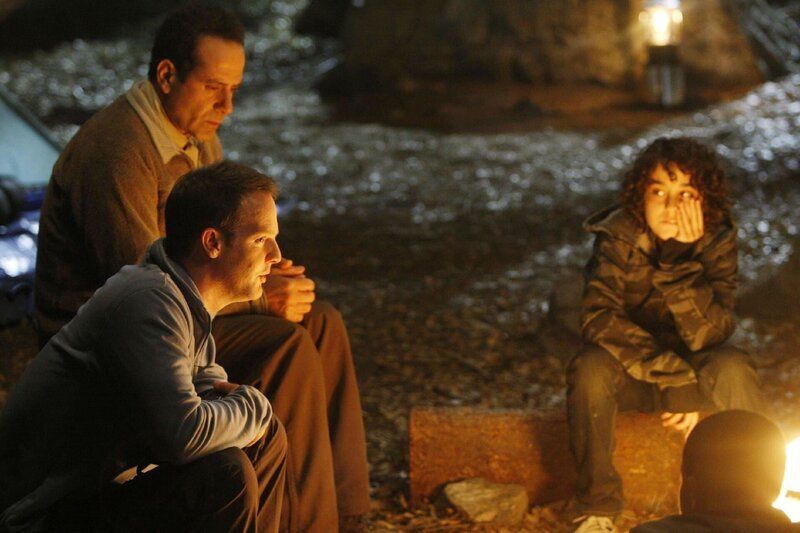 Monk (Tony Shalhoub, hi.li.), der Randall (Jason Gray-Stanford, vo.li.) und einige Kinder zu einem Campingausflug begleitet, lauscht der Geschichte, die Randall Brian (Alex Wolff) und den anderen Kids am Lagerfeuer erzählt. – Bild: RTLplus