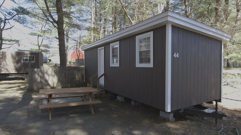 A before shot of the outdated exterior of a cabin at the Country Barn Motel in Nashua, NH, as seen on Travel Channel’s Hotel Impossible. – Bild: 2015, The Travel Channel, L.L.C. All Rights Reserved.