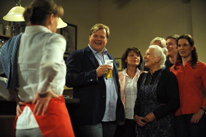 Vroni hält vor Schreck die Luft an, als Max eine Überraschung verkünden will. Von links: Veronika (Senta Auth), Max (Michael Grimm), Rosi (Brigitte Walbrun), Ludwig (Martin Wenzel) und Theresa Brunner (Ursula Erber). – Bild: Marco Orlando Pichler /​ BR