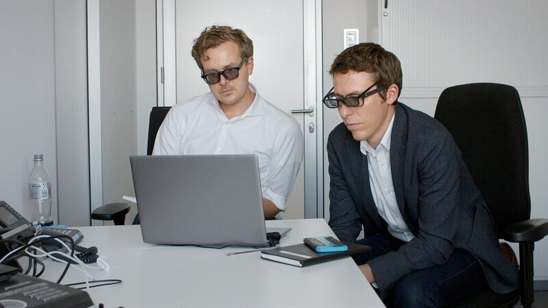 v.li.: Die Journalisten Frederik Obermaier und Bastian Obermayer schauen sich mithilfe von Spezialbrillen ein geleaktes Video an. – Bild: SRF/​Bauderfilm