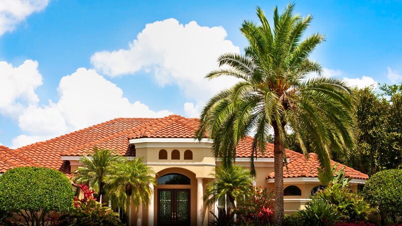 New luxury home with palm trees, flowers, green lawn and lush tropical foliage. – Bild: TLC Marje /​ Getty Images /​ GettyImages-155133397 /​ Marje Cannon