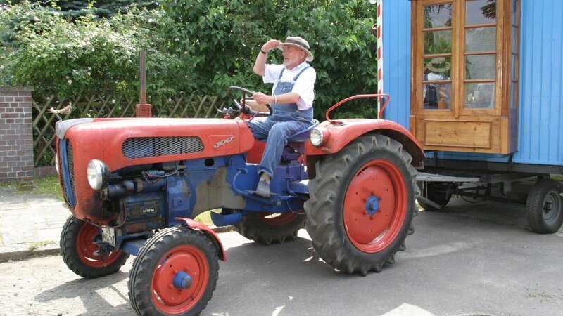 Peter (Peter Lustig) hat sich entschlossen, sein Grundstück im geliebten Elchwinkel zu verlassen und macht sich mit Bauwagen und Trecker auf den Weg ins neue Heim, ein Schlösschen auf dem Lande. – Bild: ZDF und C. Pausch Fotografie
