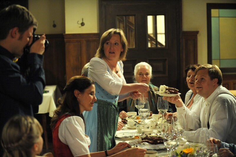 Ludwig macht ein paar Schnappschüsse von Theres Geburtstag. Von links: Caro Ertl (Teresa Rizos), Ludwig (Martin Wenzl), Annalena (Heidrun Gärtner), Veronika (Senta Auth), Theresa (Ursula Erber), Rosi (Brigitte Walbrun) und Max Brunner (Michael Grimm). – Bild: Marco Orlando Pichler /​ BR