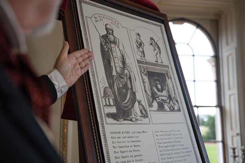 Ein Mann zeigt auf eine Tafel mit Informationen über St. Nicholas – Bild: stan /​ © THE HISTORY CHANNEL /​ A+E Networks, Harriet Laws-Herd