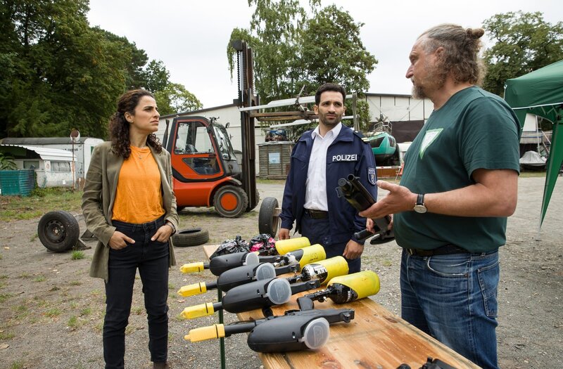 „Männerschutz“-Betreiber Uwe Brandis (Matthias Komm, r.) behauptet gegenüber Jasmin Sayed (Sesede Terziyan, l.) und Fahri Celik (Hassan Akkouch, M.), nur Sportwettbewerbe auszurichten. – Bild: ARD/​Daniela Incoronato