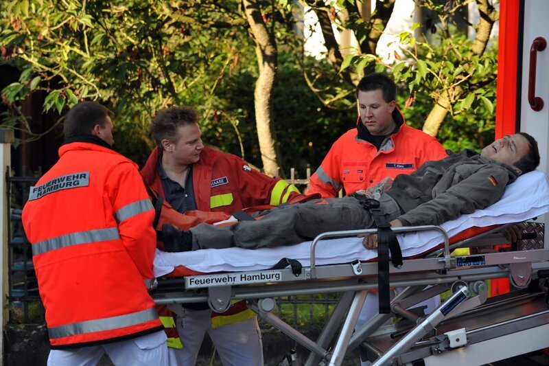 Notarzt Haase (Fabian Harloff, 2.v.l.) und seine Kollegen (Komparsen) versorgen den auf Heimaturlaub befindlichen Bundeswehrsoldaten Marco (Peter Sikorski, liegend), auf den ein Anschlag verübt wurde. – Bild: ZDF und Boris Laewen