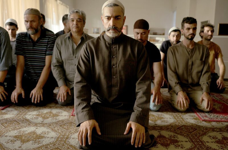 Der Imam Sheik Ibrahim Al-Khatib (Neil Malik Abdullah, vorne) ist Oberhaupt einer islamischen Gemeinde. – Bild: CH Media