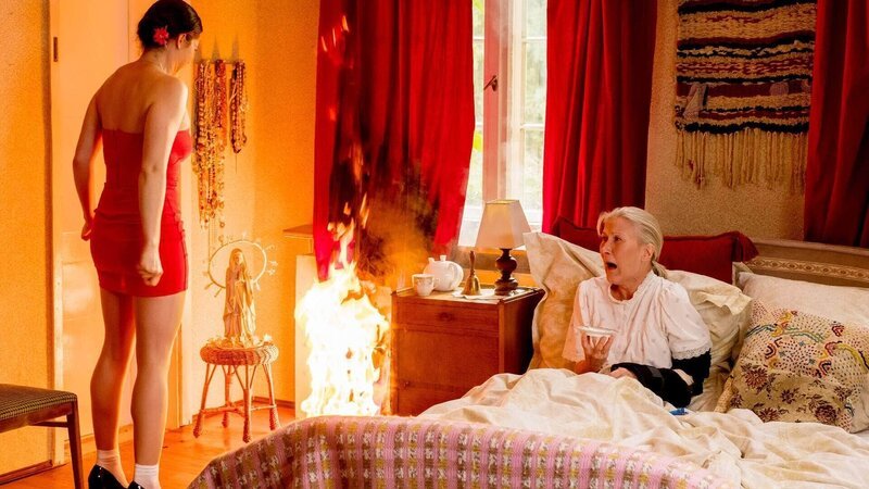 Es brennt! Während Magda (Verena Altenberger, l.) sich im Badezimmer zum Ausgehen zurecht gemacht hat, unterzog Waltraud (Hedi Kriegeskotte) den neuen Feuermelder einem Ernstfalltest und steckte dabei ihren Vorhang in Brand … – Bild: TVNOW /​ Gordon Mühle