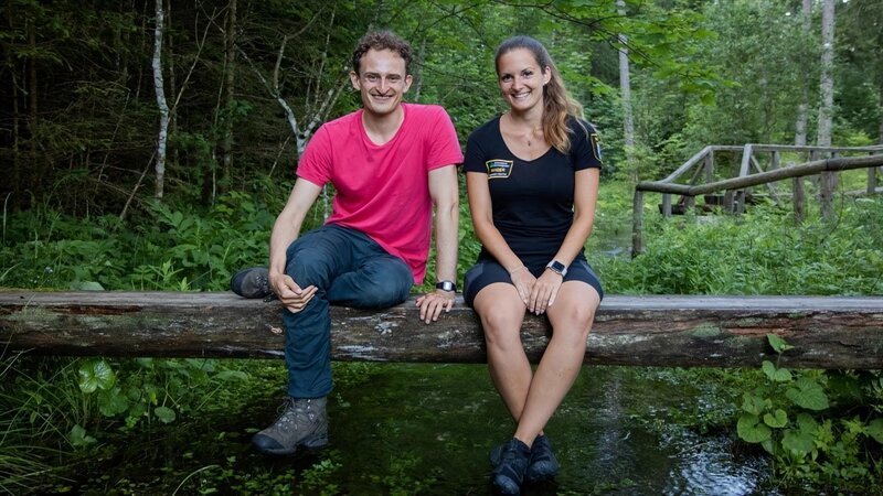Checker Julian entdeckt im Bach mit Rangerin Sabrina Köcherfliegenlarven und erfährt, was diese über die Wasserqualität aussagen. – Bild: BR/​megaherz gmbh/​David Birzer