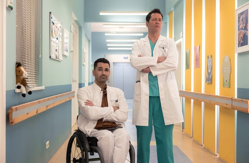 Dr. Philipp Brentano (Thomas Koch, re.) und Dr. Ilay Demir (Tan Caglar, li.) beobachten eine Kollegin und trauen ihren Augen nicht. – Bild: MDR/​Saxonia Media/​Rudolf Wernicke