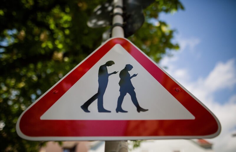 Deutschland wird immer digitaler. Damit die auf ihr Handy starrenden „Smombies“ nicht bei Rot über die Straße laufen, werden in manchen deutschen Städten sogar Bodenampeln installiert. – Bild: ZDF und picture alliance /​ DN | Mickan Palmqvist/​DN/​TT