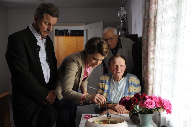 Bürgermeister Schattenhofer ist sichtlich betroffen, als er mit Maria die alte Dame besucht. Von links: Bürgermeister Schattenhofer (Werner Rom) und Maria Kirchleitner (Daniela März). – Bild: Marco Orlando Pichler /​ BR