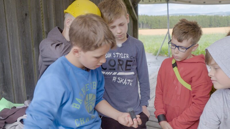 Gespannt schauen die anderen Jungs Alvin beim Devilstickbauen über die Schulter. – Bild: MDR/​Cine Impuls Leipzig