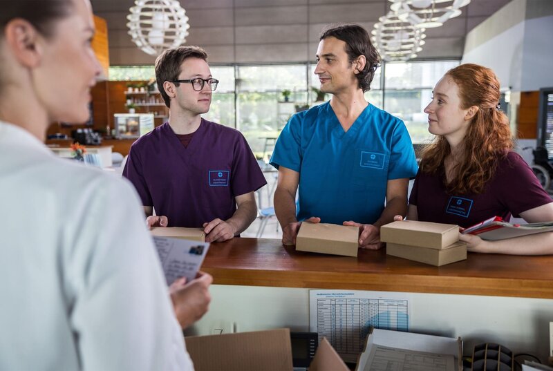 Die jungen Ärzte sind genau ein Jahr im JTK! Zu dem Anlass hat Olli (Arne Kertész), Ivo (Jakob D’Aprile) und Tamar (Linda Kummer) ein Paket mit einer Aufmerksamkeit erreicht, die Sie von Dr. Julia Berger (Mirka Pigulla) überreicht bekommen. Von wem kommt die überraschende Zusendung? (v.l.n.r. Dr. Julia Berger (Mirka Pigulla), Olli (Arne Kertész), Ivo (Jakob D’Aprile), Tamar (Linda Kummer)). – Bild: ARD/​Michael Kremer