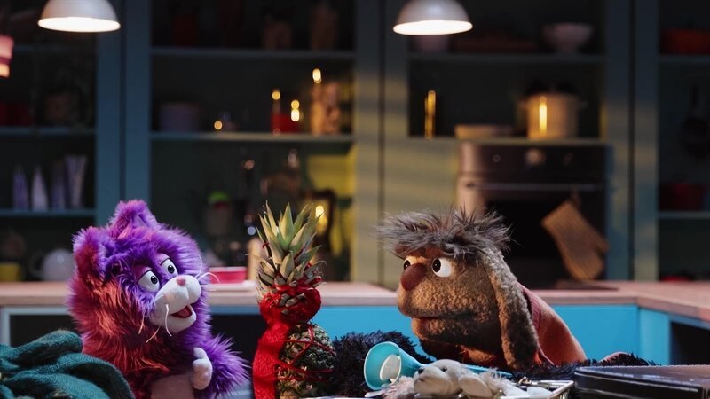 MiWau strickt eine Hülle für die Ananas, damit sie sich an dieser wärmen kann. Auch dieser Plan scheitert. – Bild: rbb/​Stefan Wieland