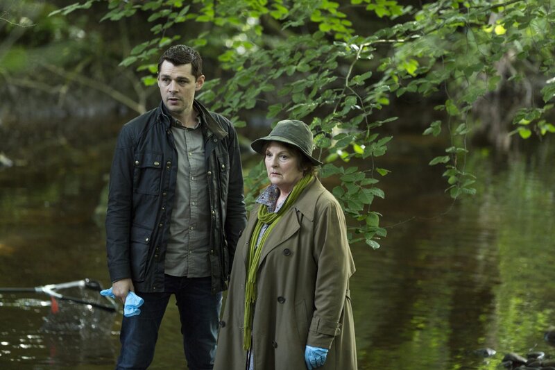 DCI Vera Stanhope (Brenda Blethyn, r.) und ihr Assistent DS Aiden Healy (Kenny Doughty, l.) schauen sich den Fundort der Leiche im Hinblick auf entscheidende Spuren nochmals an. – Bild: ITV Studios Limited