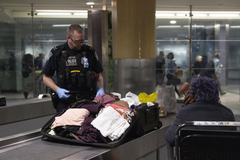 Officer Tighe McIntrye searches through incoming passengers’ luggage. (National Geographic/​Lucky 8 TV) – Bild: 2021 NGC Network US, LLC. All rights reserved. Lizenzbild frei