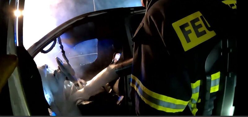 Auf einem abgesperrten Parkplatz brennt ein Kleintransporter. Die Feuerwehrmänner der Feuerwehr Wuppertal verschaffen sich über eine Leiter Zutritt und löschen den Brand mit Wasser und Schaum. – Bild: RTL