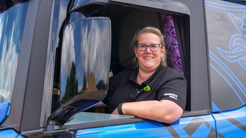 Tina sitzt im Truck, schaut aus dem Fenster, streckt die Ellbogen aus dem Fenster und lächelt. – Bild: DMAX – Germany /​ Preview Production GbR