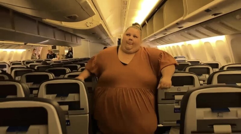 Stephanie geht durch die Gänge eines Flugzeugs. – Bild: TLC