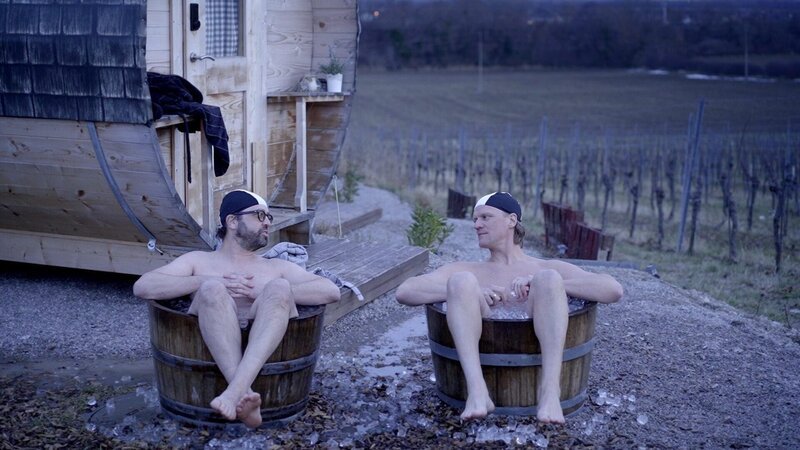 Gerald Fleischhacker und Gery Seidl sitzen in Eiswasser in einem Weinfass. – Bild: ORF/​TVfriends