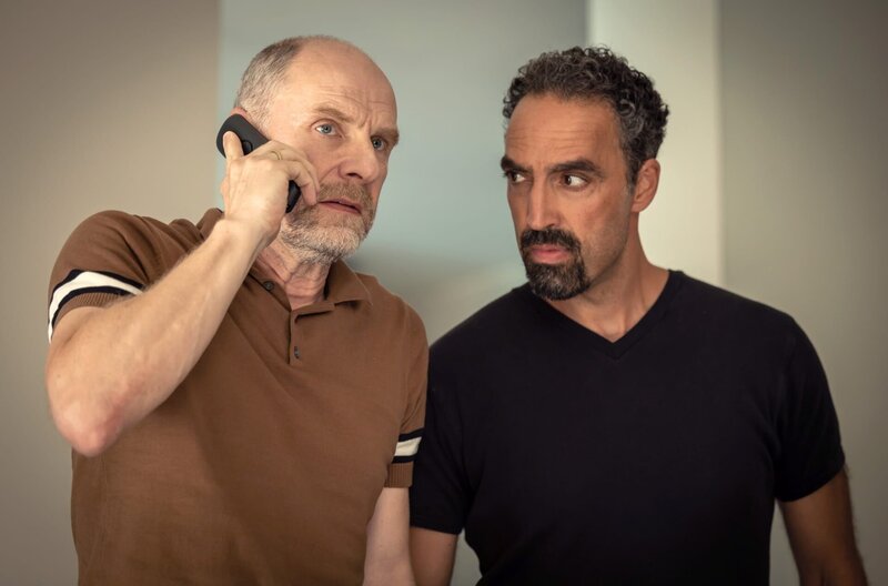 Richard (Götz Schubert, li.) erhält einen plötzlichen Anruf und vermutet, dass es sich um Chris’ Entführer handelt. Hanno (Samir Fuchs, re.) unterstützt die Familie in dieser schwierigen Situation. – Bild: WDR/​Constantin Film/​Michel Vertongen