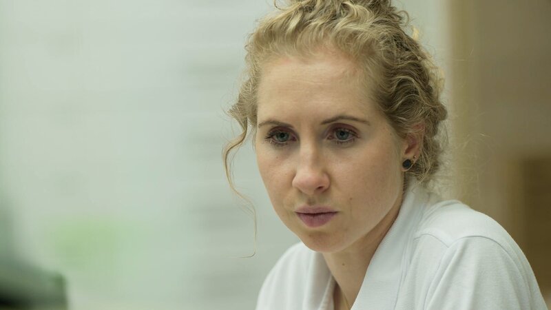Ep4 – Super close-up shot of a blonde young physician looking down and intently probably at a screen, that is not depicted on the picture. She is wearing white and her locks are bundled in a bun. – Bild: Warner Bros. Discovery, Inc. or its subsidiaries and affiliates.