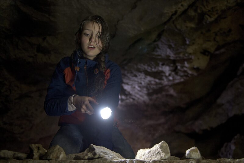 Hanna (Antonia Wiedemann) ist mit ihrem Bruder und dem Meteorologen Ralf in einer Höhle gefangen. Ein Unwetter macht ein Weitergehen unmöglich. – Bild: ZDF und Thomas R. Schumann