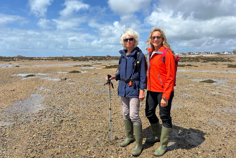 Tamina Kallert (r) wandert mit der Geografin und Wanderführerin Trudie Hairon-Trox bei Ebbe durch die Königliche Bucht von Grouville. – Bild: WDR/​Beate Höfener