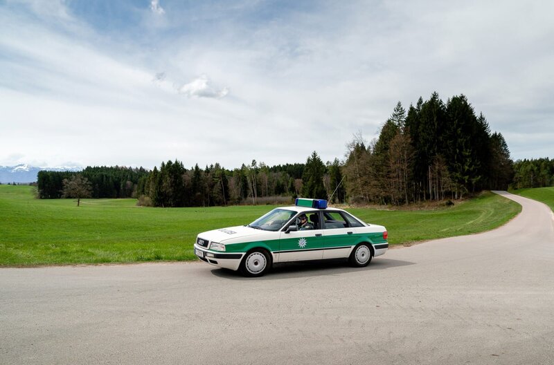 Hubert (Christian Tramitz) und Girwidz (Michael Brandner) sind mit dem Streifenwagen unterwegs. – Bild: ARD/​TMG/​Arvid Uhlig