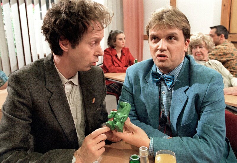 Die Aufgabe, in stiller Gruppenarbeit Probleme zu kneten, wird von Gisbert (Hape Kerkeling) und Hubert Weber (Gottfried Vollmer, li.) bravourös mit der Herstellung eines giftgrünen ‚Männeken Piss‘ bewältigt. – Bild: WDR/​Frank Schulte