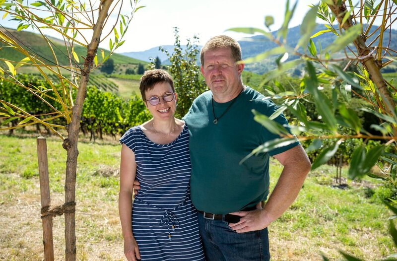Einen Weinberg bei Bühl in ein Selbstversorgerparadies umzugestalten ist die Vision von Frank Fröhlich (r). Der Winzersohn wollte den konventionellen Rebenanbau aus ökologischen Gründen nicht fortführen und versucht nach den Regeln der Permakultur den ausgelaugten Boden wieder zu beleben. Statt Monokultur soll ein Naturgarten entstehen, der Mensch und Tier Nahrung und Rückzugsraum bietet. Um sich mit voller Kraft dem 6000 Quadratmeter großen Gelände widmen zu können, hat der leidenschaftliche Hobbygärtner in Absprache mit seiner Ehefrau Sonja (l) den Beruf als Schulsozialarbeiter an den Nagel gehängt, so dass Sonja nun Alleinverdienerin der dreiköpfigen Familie ist. – Bild: WDR/​Melanie Grande