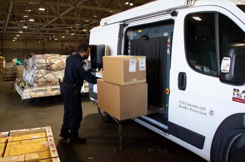 Officer Richard Stephens places packages on X-ray machine for a thorough inspection. (National Geographic/​Lucky 8 TV) – Bild: 2021 NGC Network US, LLC. All rights reserved. Lizenzbild frei
